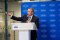 Didier Genois s'exprimant lors de l'inauguration de l'extension du laboratoire de R&D de Carrier à Montluel, depuis une tribune installée devant une toile de fond aux couleurs de la marque Carrier