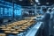 Opérateurs en tenue stérile surveillant une ligne de production alimentaire avec des écrans numériques affichant des données en temps réel.