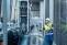 Technicien de maintenance industrielle contrôlant des vannes de tuyauterie en extérieur et communiquant par radio sur un site industriel