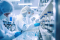Personnes portant un masque et travaillant dans une usine pharmaceutique