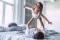 Père et fille jouant joyeusement sur un lit dans une chambre lumineuse et confortable