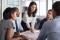 Équipe d'affaires diversifiée collaborant dans un bureau moderne, avec une femme menant la discussion