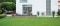 Unité extérieure d'une pompe à chaleur Carrier AquaSnap installée à côté d'une maison blanche moderne avec un patio en bois.