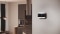 L'image montre le thermostat Carrier Comfort Management T300 accroché au mur d'un salon moderne.